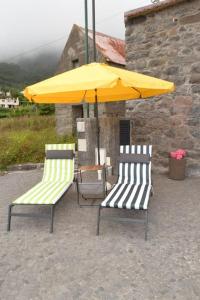 two chairs and a yellow umbrella on a patio at Sonho Paixão in São Vicente