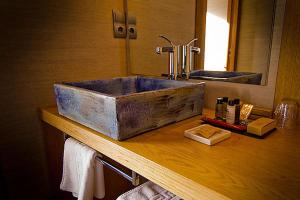 baño con lavabo de piedra en la encimera en La Casona de Abamia, en Corao