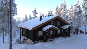 a log cabin with snow on the roof at Villa Immellompolo in Levi