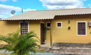 伦索伊斯Casa Ipê的黄色的房子,有门和棕榈树