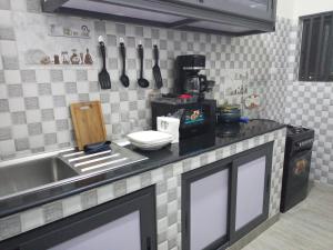 a kitchen with a sink and a counter with utensils at RG Résidences in Cotonou