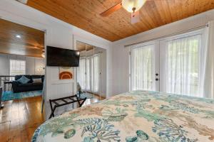 a bedroom with a bed and a flat screen tv at Bare Feet Bungalow -Close to beach & dog friendly in Gulfport