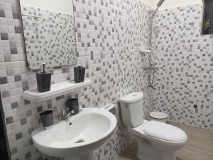 a bathroom with a sink and a toilet and a mirror at RG Résidences in Cotonou +18 photos