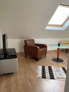 a living room with a chair and a table at gemütliche Wohnung, tolle Lage, auch für Messe in Meerbusch