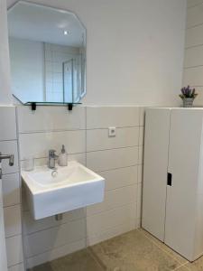 a bathroom with a white sink and a mirror at gemütliche Wohnung, tolle Lage, auch für Messe in Meerbusch +4 photos