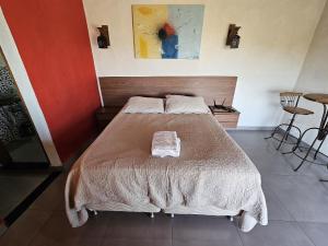 a bedroom with a bed with two towels on it at Chalés Vila Real - Tranquilidade na Serra de Carrancas - Piscina com uma vista espetacular do Pôr do Sol in Carrancas