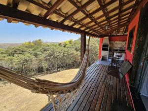 a hammock on the porch of a house at Chalés Vila Real - Tranquilidade na Serra de Carrancas - Piscina com uma vista espetacular do Pôr do Sol in Carrancas