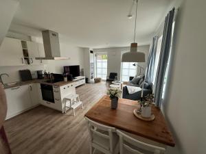 a kitchen and a living room with a table and chairs at Linnebarg Hus 1 in Bisdorf