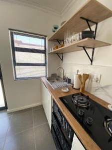 eine Küche mit Herd und Arbeitsplatte in der Unterkunft Cottage on 36 Neethlingshof in Kapstadt