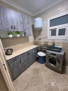 une cuisine avec une machine à laver et un évier dans l'établissement Madinaty, à Madinaty