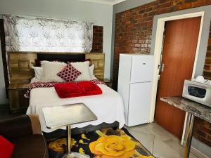 um quarto com uma cama com almofadas vermelhas em Goodlife guest house in klerksdorp em Klerksdorp