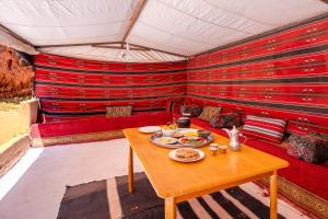 a room with a table with plates of food on it at Wadi Rum night soul Camp in Wadi Rum