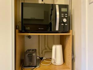 eine Mikrowelle und ein Toaster im Regal in der Unterkunft Appartement proche Centre-ville- Fibre in Saint Lo + 4 Fotos