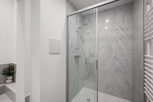 eine Dusche mit Glastür im Badezimmer in der Unterkunft Ferienwohnung Blaßdörfer - Modernes Apartment in bester Lage und 93 qm2 in Bad Kissingen
