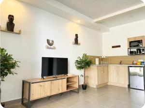 a living room with a flat screen tv on a wall at Serenity Lodge Tahiti Fare Haumana in Outu Maoro