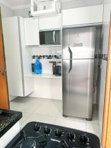 um frigorífico de aço inoxidável numa cozinha branca em Hospedagem Congonhas 4 em São Paulo
