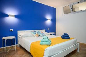 een blauwe slaapkamer met een bed met handdoeken erop bij Nice and cozy apartment in Àrbatax