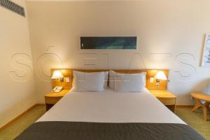 AldeiaHotel e Residencia Sequoia的一间卧室，有一张床，两张桌子和两盏灯