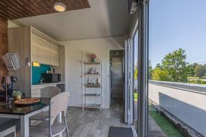 a kitchen and dining area of a tiny house with a balcony at Rooftop Home With Whirlpool & Sauna - Happy Rentals in Trebnje