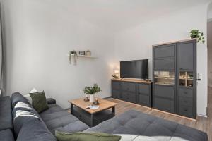 a living room with a couch and a tv at Ferienwohnung Blaßdörfer - Traumhafte Altbauwohnung mit Self-Checkin und 93 qm2 in Bad Kissingen