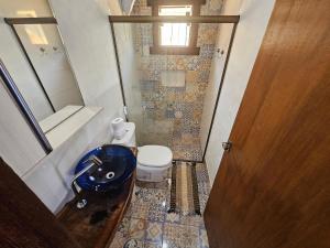 a small bathroom with a sink and a toilet at Chalés Vila Real - Tranquilidade na Serra de Carrancas - Piscina com uma vista espetacular do Pôr do Sol in Carrancas