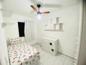 a white bedroom with a bed and a ceiling fan at Apartamento A 700m da orla mais bonita do país no bairro Atalaia in Santa Maria