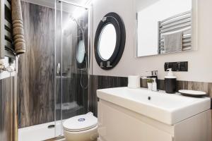 a bathroom with a toilet and a sink and a shower at Water Lodge in London - Roof Terrace in London +12 photos