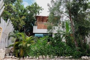 a house surrounded by trees and a fence at The Village K´AAX in Tulum