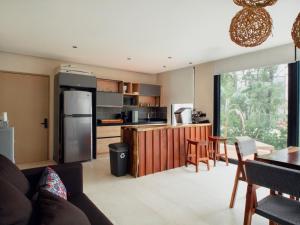 a kitchen and living room with a refrigerator and a table at The Village K´AAX in Tulum