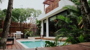 a house with a swimming pool in a yard at The Village K´AAX in Tulum