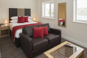 um quarto com uma cama, um sofá e uma cadeira em House of Fisher - Beneficial House em Bracknell