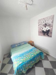 a bed in a room with a picture on the wall at Dar lmedina in Essaouira