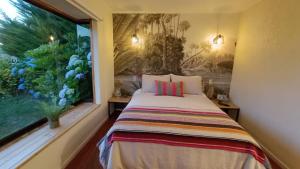 a bed in a room with a window at Cabañas Montenegro in Villarrica
