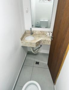 uma casa de banho com um lavatório e um WC com um espelho. em Hospedagem Congonhas 5 em São Paulo mais 10 fotografias