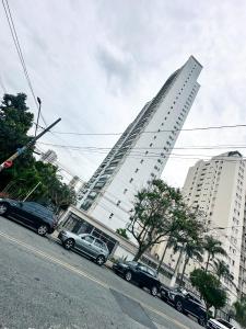 um edifício alto com carros estacionados ao lado de uma rua em Hospedagem Congonhas 5 em São Paulo