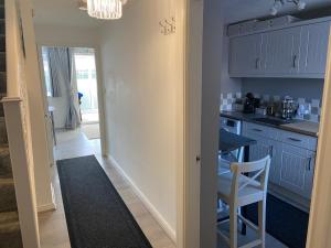 a kitchen with blue cabinets and a table and a chair at Extra Apartment in Stainforth