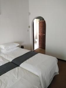 a bedroom with a white bed with a black and white blanket at Bed on 22 in Ballito