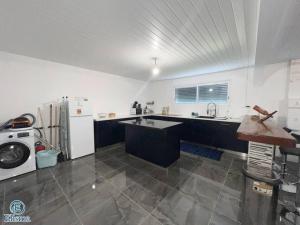 a large kitchen with a sink and a refrigerator at Elisma hébergement in Kourou