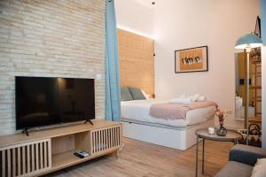 a living room with a large television and a bed at Lofts Orense E Moderno y cercano a la playa in Valencia