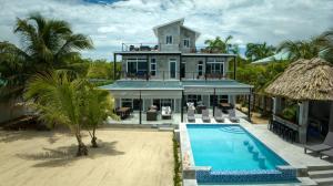 an aerial view of a house with a swimming pool at Conmigo Villas - 6 Bedroom Beachfront w Pool in Maya Beach