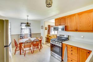 a kitchen with wooden cabinets and a table with chairs at Vacation Rental Near South Dakota State University in Brookings +19 photos