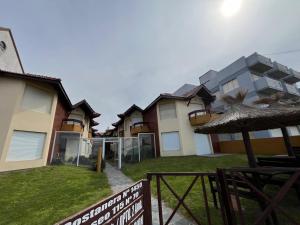 eine Gruppe von Häusern in einem Hof mit einem Sonnenschirm in der Unterkunft Duplex frente al Mar en Villa Gesell in Villa Gesell