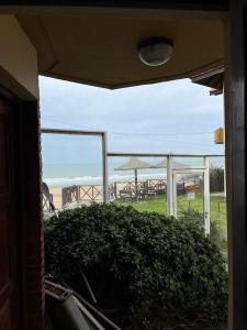 Blick auf den Strand von einem Fenster des Hauses in der Unterkunft Duplex frente al Mar en Villa Gesell in Villa Gesell + 3 Fotos
