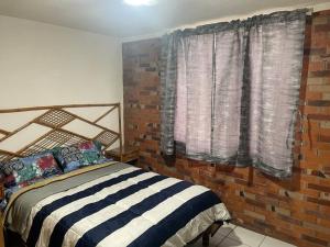 a bedroom with a bed and a brick wall at Depa cerca hospital Issste y jardines de fiesta in Emiliano Zapata +31 photos