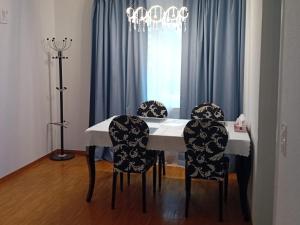 a dining room table with four chairs and a chandelier at 3 Room Premium Apartment Buchs SG in Buchs