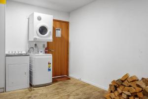 Una cocina con estufa y refrigerador y una pila de leña. en *** LAKE VILLA 457 ***, en Hanmer Springs