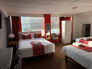 a hotel room with two beds and a window at Hotel Plateros in Cusco +80 photos