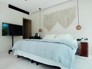 um quarto branco com uma cama grande e lençóis azuis em Deluxe Tulum Villa KIIN em Tulum