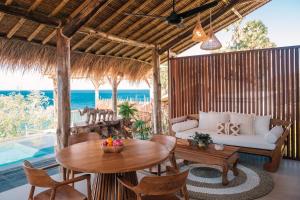 a living room with a table and a couch at Abing Villas Spa & Beach Bar in Amed