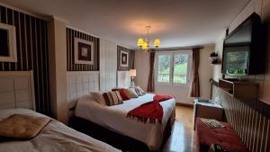 a hotel room with two beds and a television at Pousada Atalaia Premium in Campos do Jordão